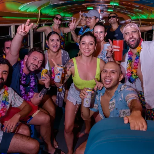 Birthday party group celebrating with drinks inside the Crawler Hauler party bus in Tamarindo