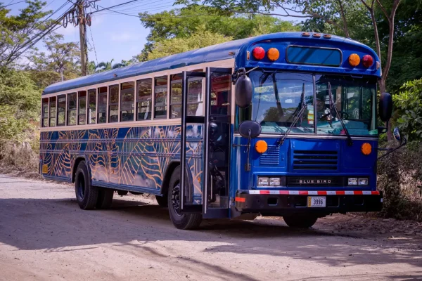 The Crawler Hauler, a blue Blue Bird party bus, parked in Tamarindo, Costa Rica