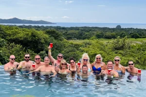 Crawl group toasting in the infinity pool at Gracia Mar Vista overlooking the Guanacaste coast, Costa Rica