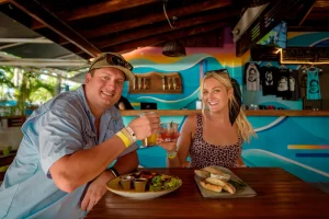 Couple toasting drinks over lunch at Hemingway's in Playa Potrero, Guanacaste