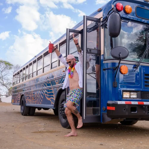 Crawler dancing in the doorway of the Crawler Hauler party bus in Tamarindo