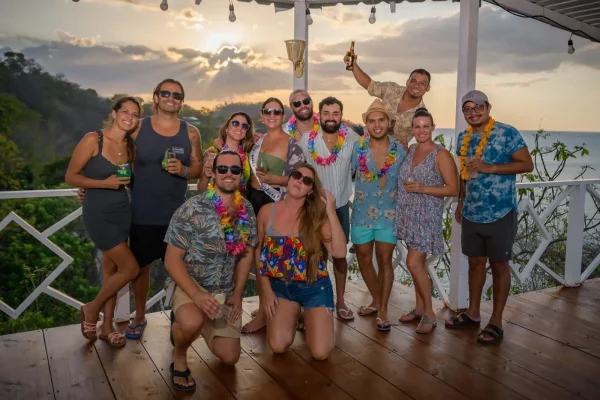 Crawl group in leis on an oceanview deck at sunset on the Guanacaste coast, Costa Rica